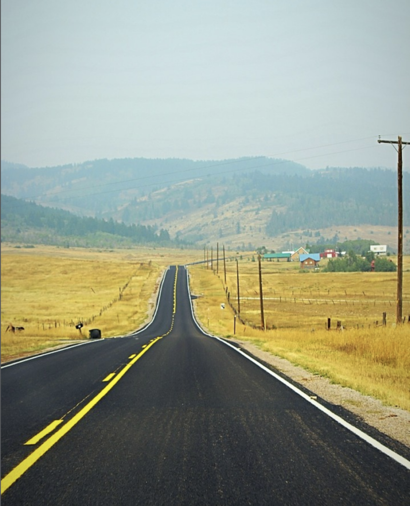 USA, Landstrasse, Blick in die Ferne auf ein paar Häuser und Berge